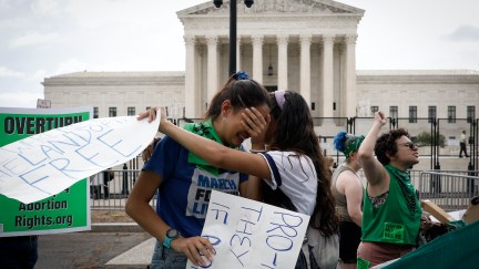 Abortion rights protesters hug and cry outside of the Supreme Court.