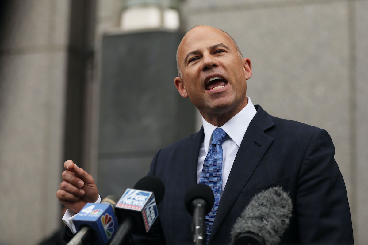 A bald white man (Avenatti) yells into microphones during a press conference