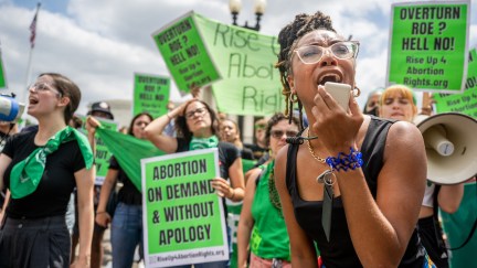 Abortion rights demonstrators rally with signs and megaphones.