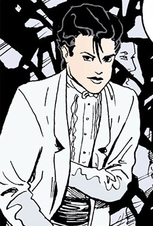 Desire, an androgynous person in a white suit with black hair, puts a hand in their coat pocket.