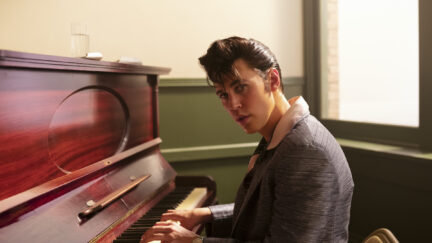 Austin Butler as Elvis, sitting at a piano looking directly into the camera to his side.