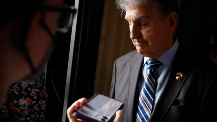 Joe Manchin looks disappointed while talking to reporters.