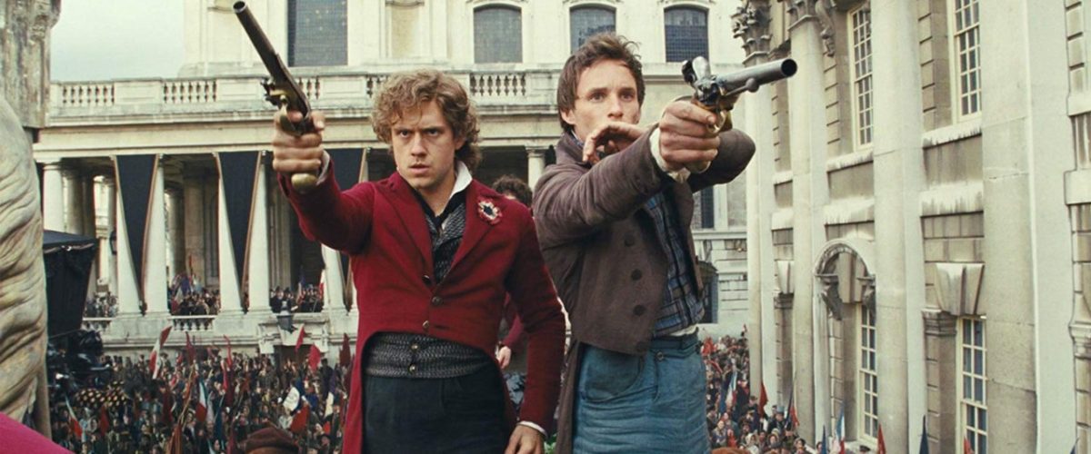 Aaron Tveit and Eddie Redmayne in Les Mis holding guns