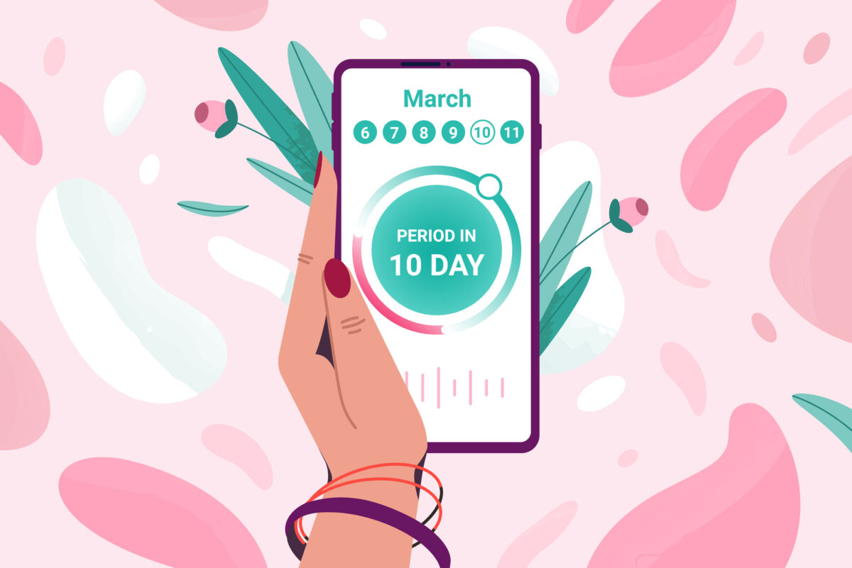 Flat tracker of menstrual period on calendar. Woman hand holding mobile phone to keep track of menstruation cycles. Girl monitoring ovulation or pregnancy period by tracking app on smartphone screen. Image: Getty/Hanna Siamashka.