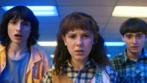 Mike Wheeler, Eleven, and Will Byers look surprised in a shot from Stranger Things Season 4