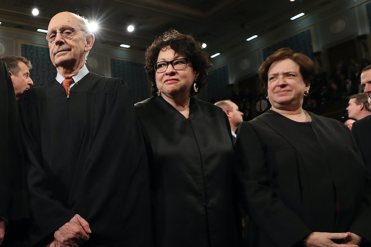 Supreme Court Justices Stephen Breyer, Sonia SOtomayor, and Elena Kagan stand in their robes
