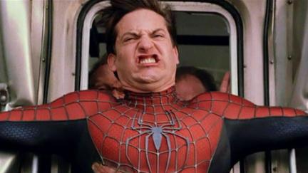 Tobey Maguire as Spider-Man grimacing as he tries to stop a train.