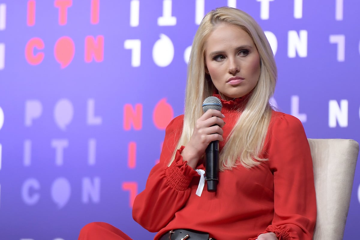A young blonde woman (Lahren) with a disapproving expression holds a microphone in front of her face, sitting onstage at the Politicon conference.