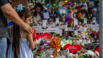 A man and little girl stand at a memorial for the victims of the school shooting in uvalde, texas