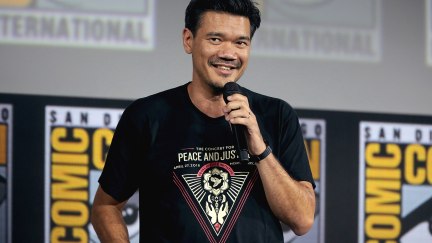 Destin Daniel Cretton standing on stage with a microphone at San Diego Comic-Con.