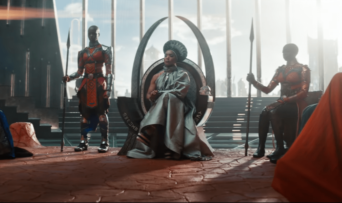 Queen Ramonda (Angela Bassett) sits in her throne, flanked by two Dora Milaje.
