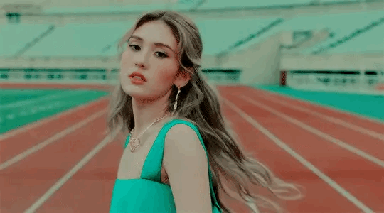 A gif of Somi from the music video for "What Are You Waiting For"