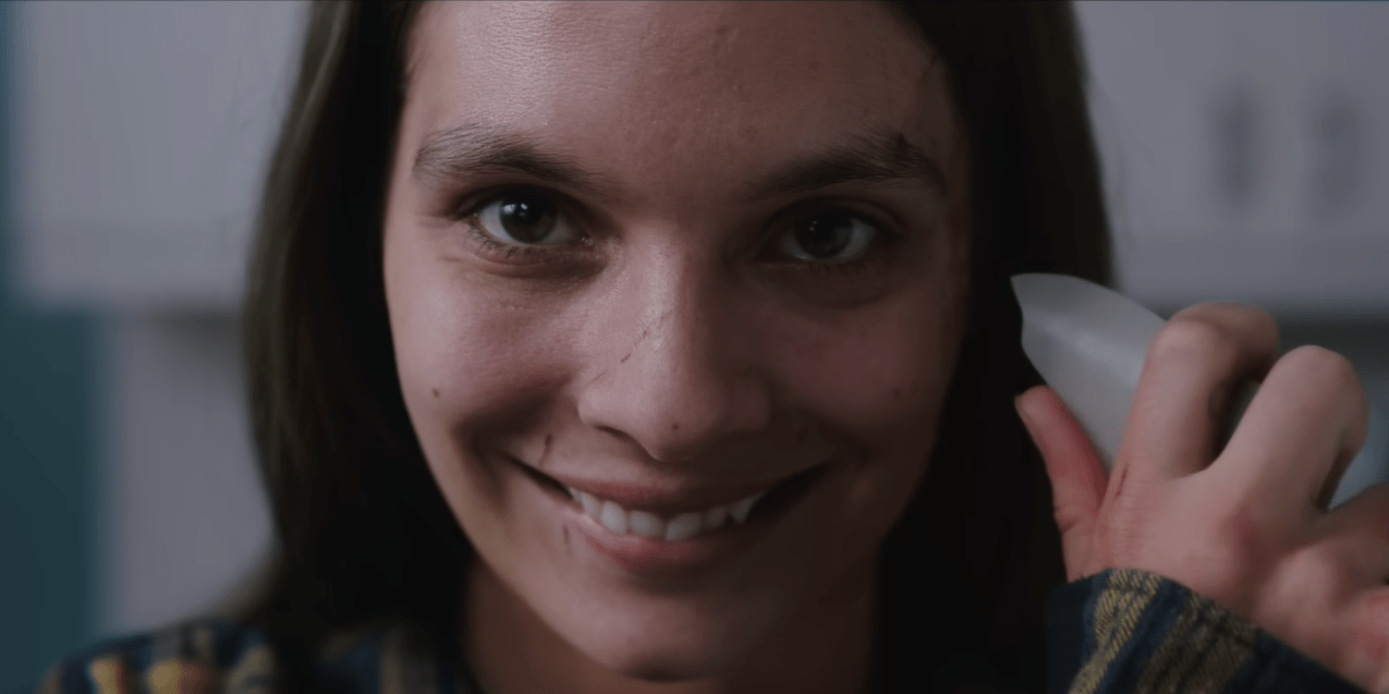 Closeup of the main character smiling with a slightly sinister tone.