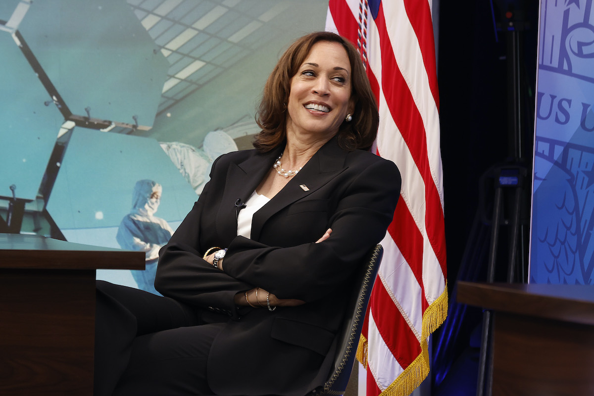 Kamala Harris leans back in a chair, crossing her arms, and laughs