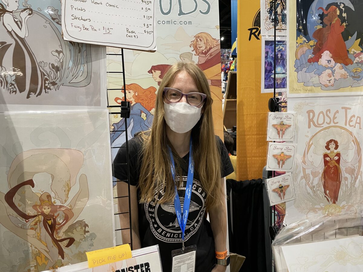 Artist Melissa Pagluica smiles at her booth at SDCC 2022.