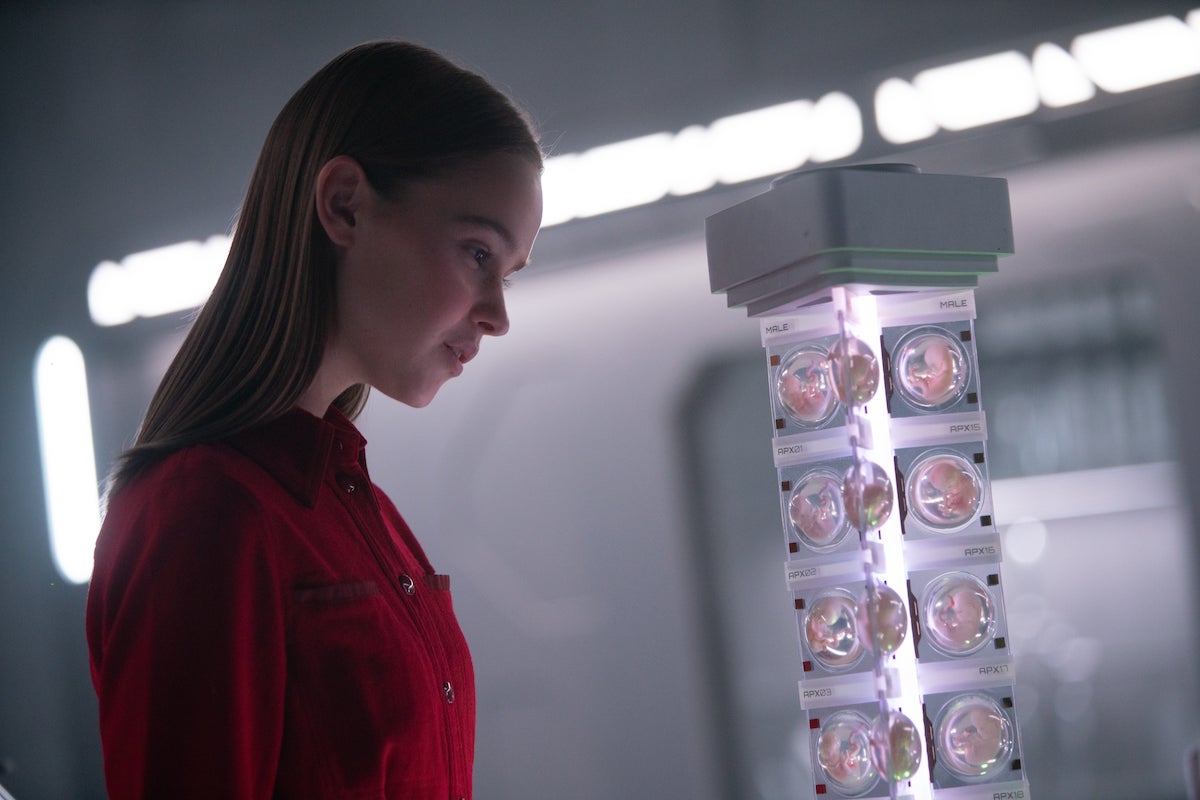Film still from I Am Mother featuring Clara Rugaard as Daughter looking at a storage container full of human embryos