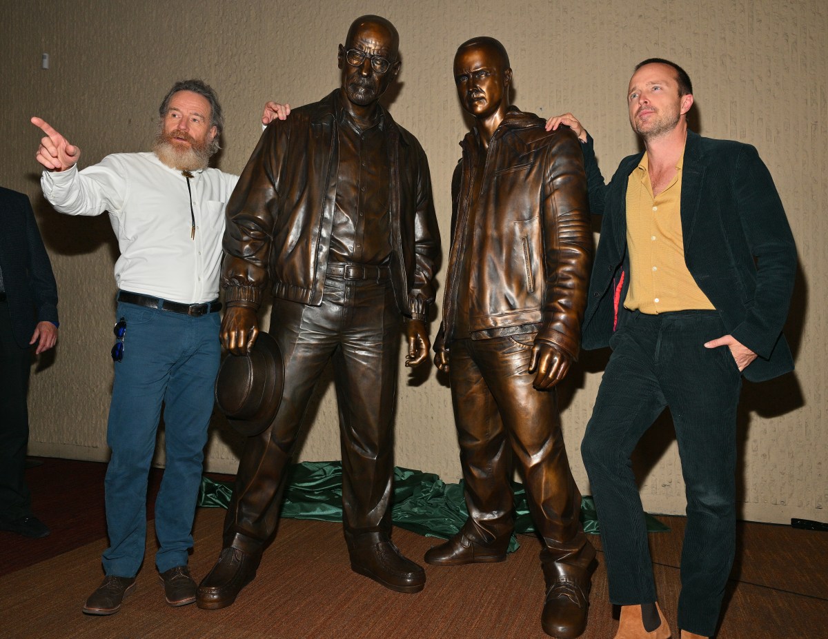 Bryan Cranston and Aaron Paul in Albuquerque New Mexico posing with statues of themselves