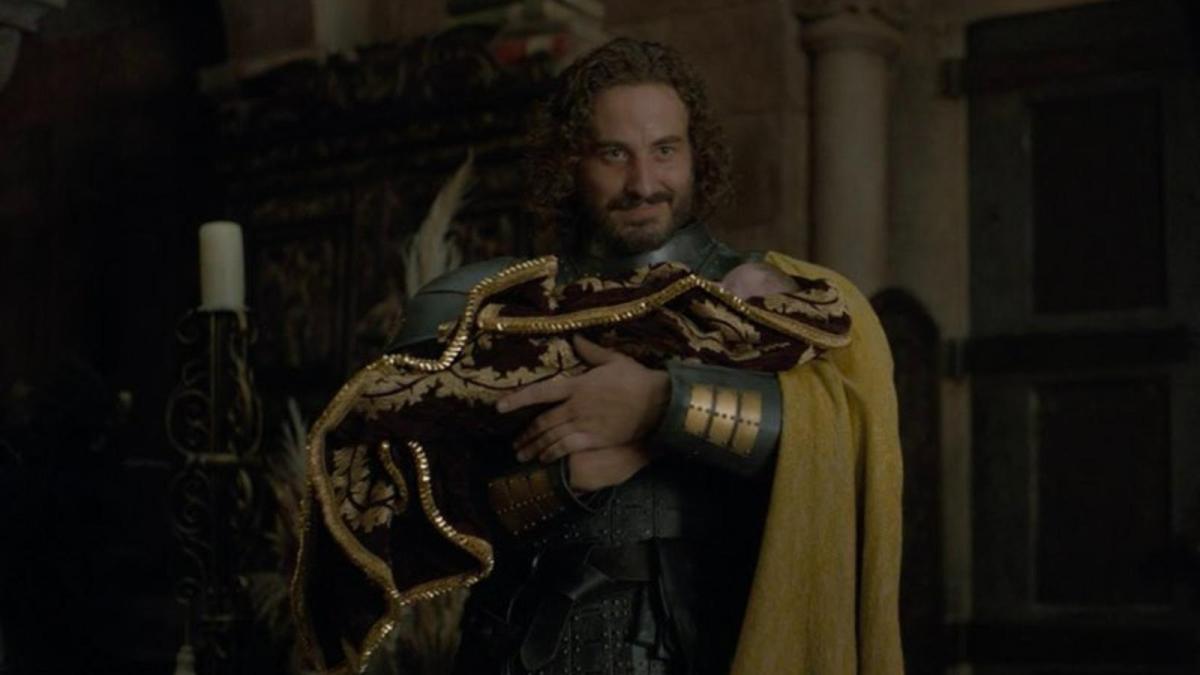 A picture of Ser Harwin Strong holding the youngest of his three children with Princess Rhaenyra in Episode 6 of House of the Dragon