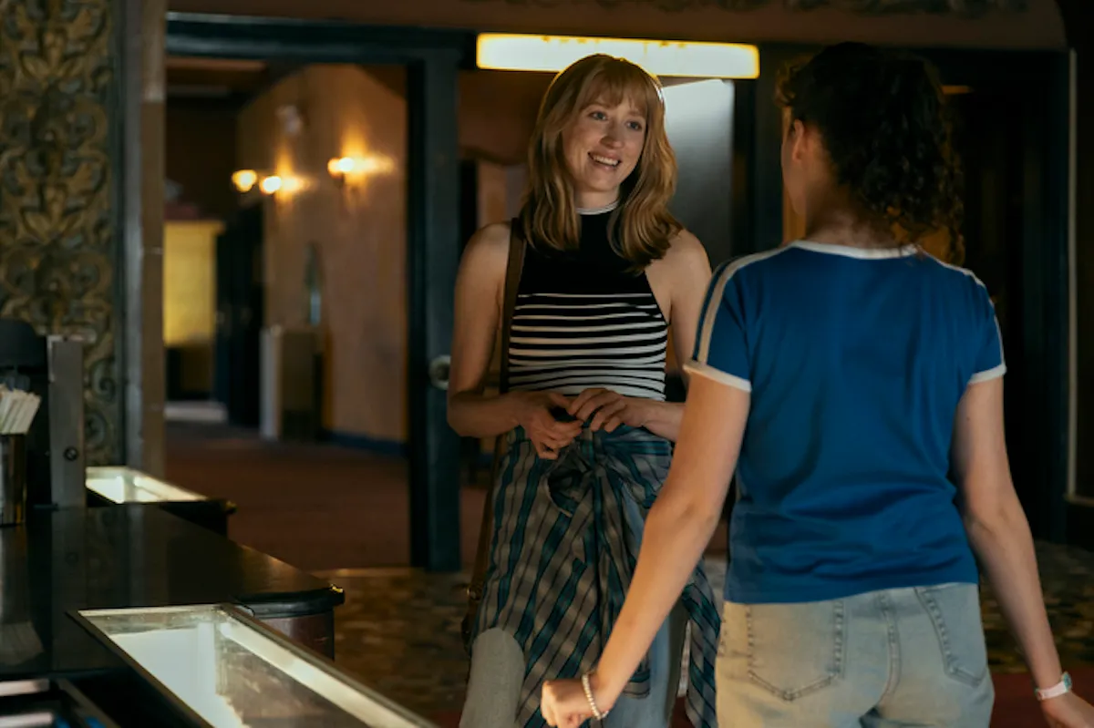 Lauren, played by Maren Lord, and KJ, played by Fina Strazza, taking privately in the lobby of a movie theater 