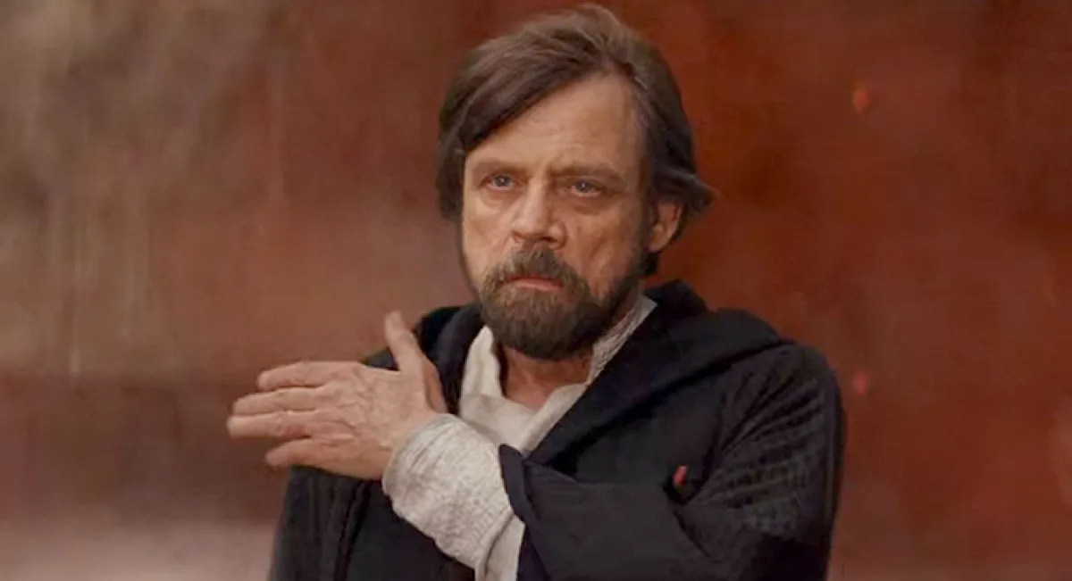 Luke Skywalker brushes dirt off his shoulder in Star Wars: The Last Jedi.