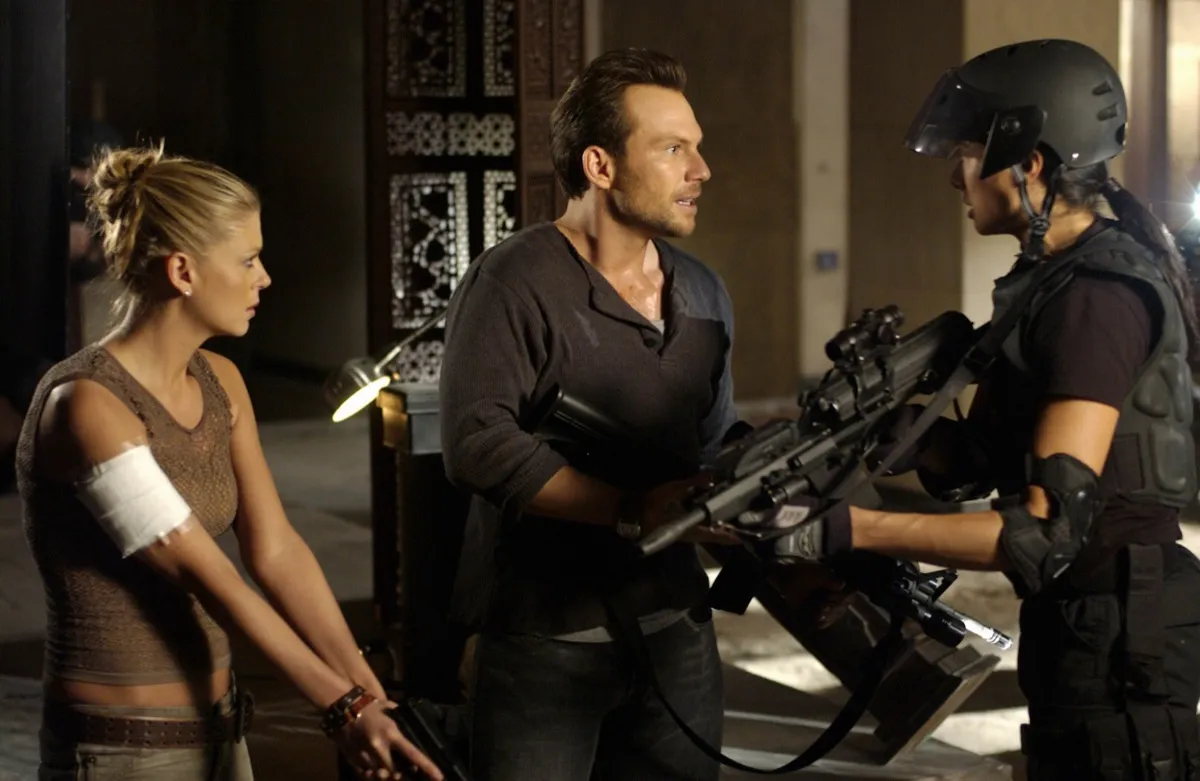 A man and woman holding guns talk to a soldier in "Alone in the Dark"