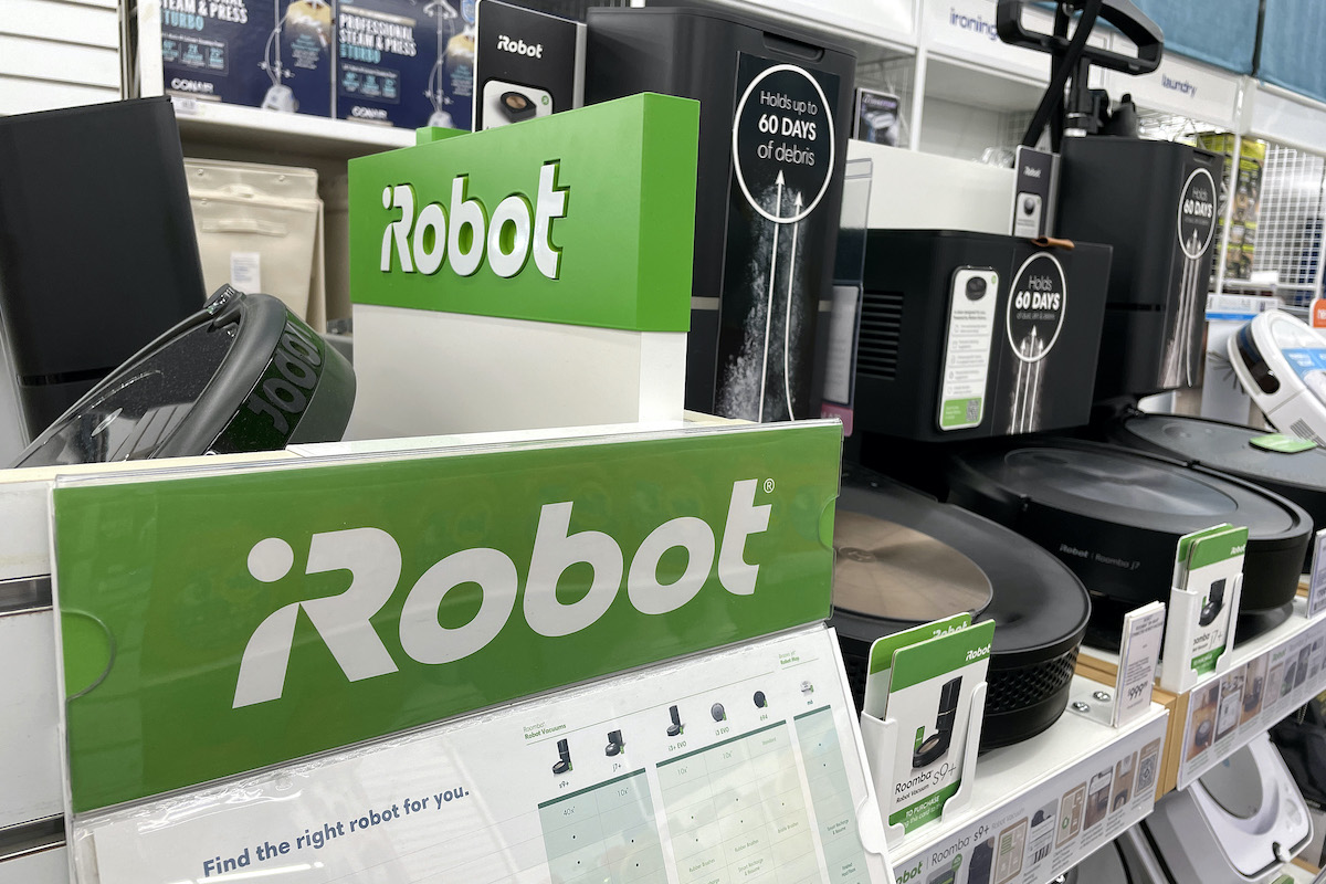 A display of iRobot Roomba vacuums on a store shelf.