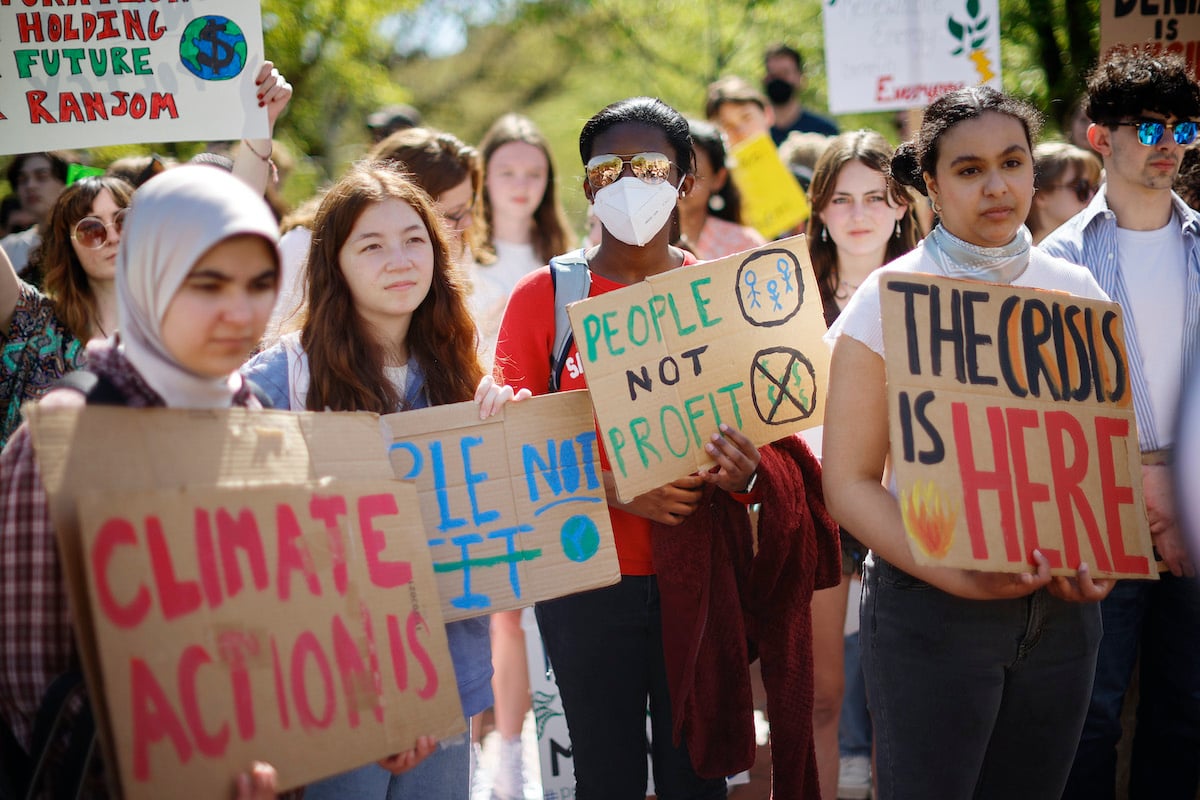 Young activists hold signs during a climate protest.