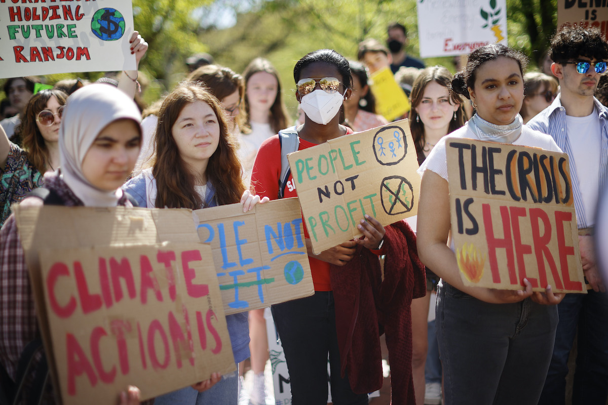 Young activists hold signs during a climate protest.
