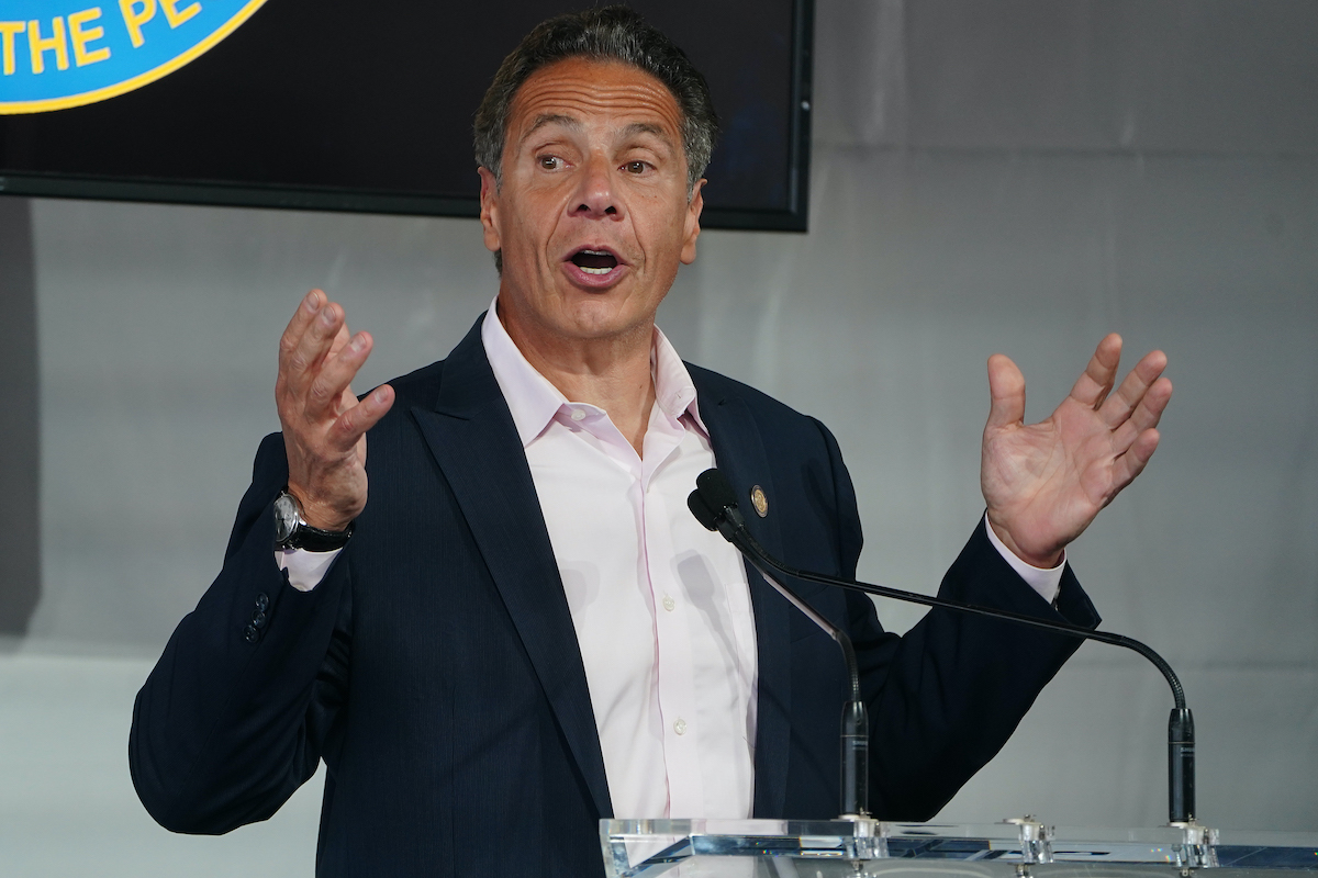 Andrew Cuomo gestures broadly while speaking from a podium.