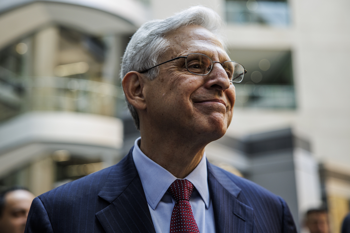 Merrick Garland gives a closed-lipped grin.