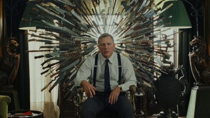 Daniel Craig as Benoit Blanc in Knives Out sitting on a throne of knives