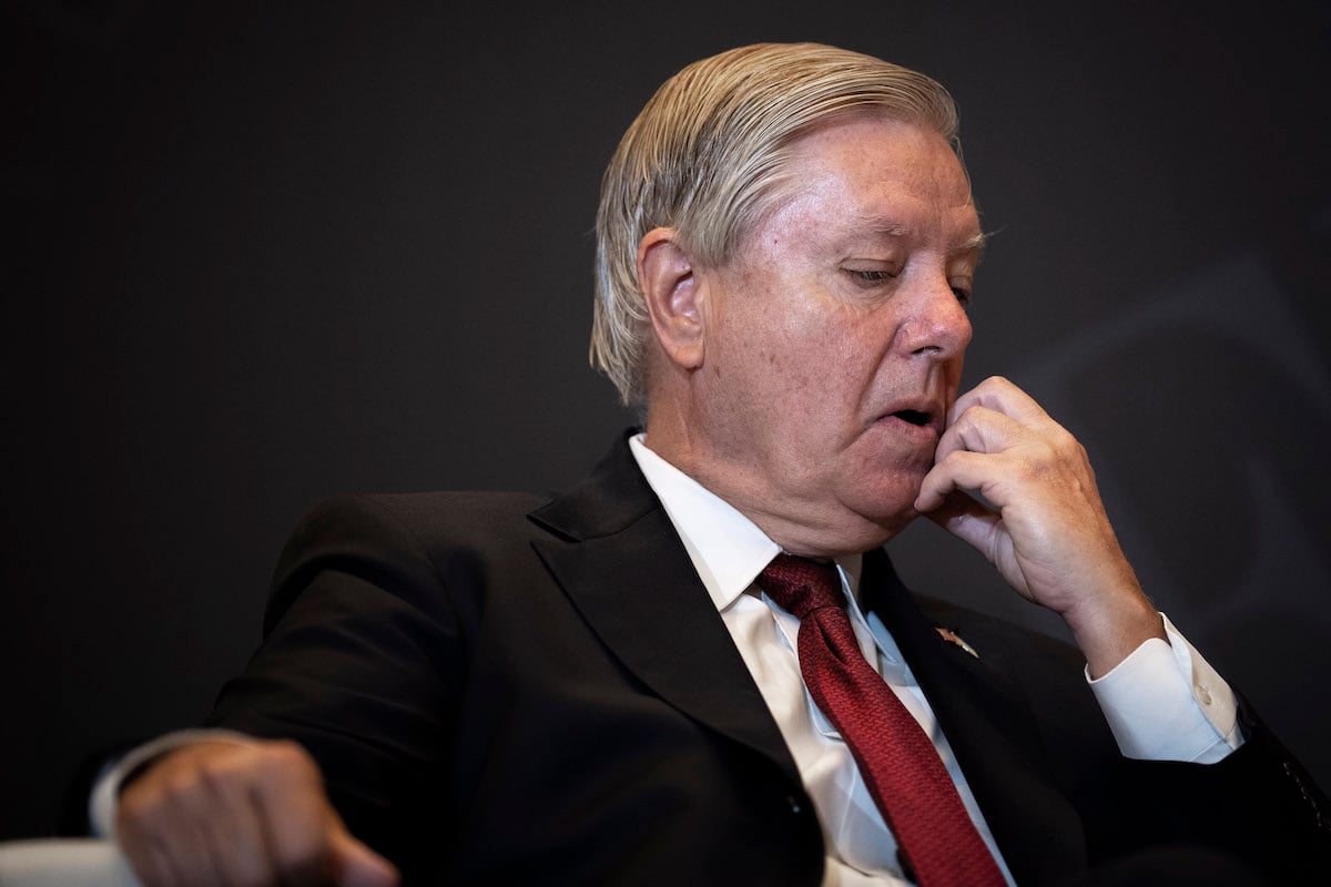 Lindsey Graham looks down and scratches his chin.