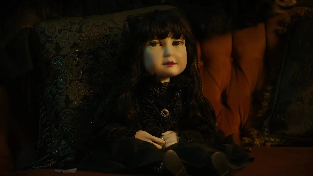 A doll that looks like Nadja sits on a chair.