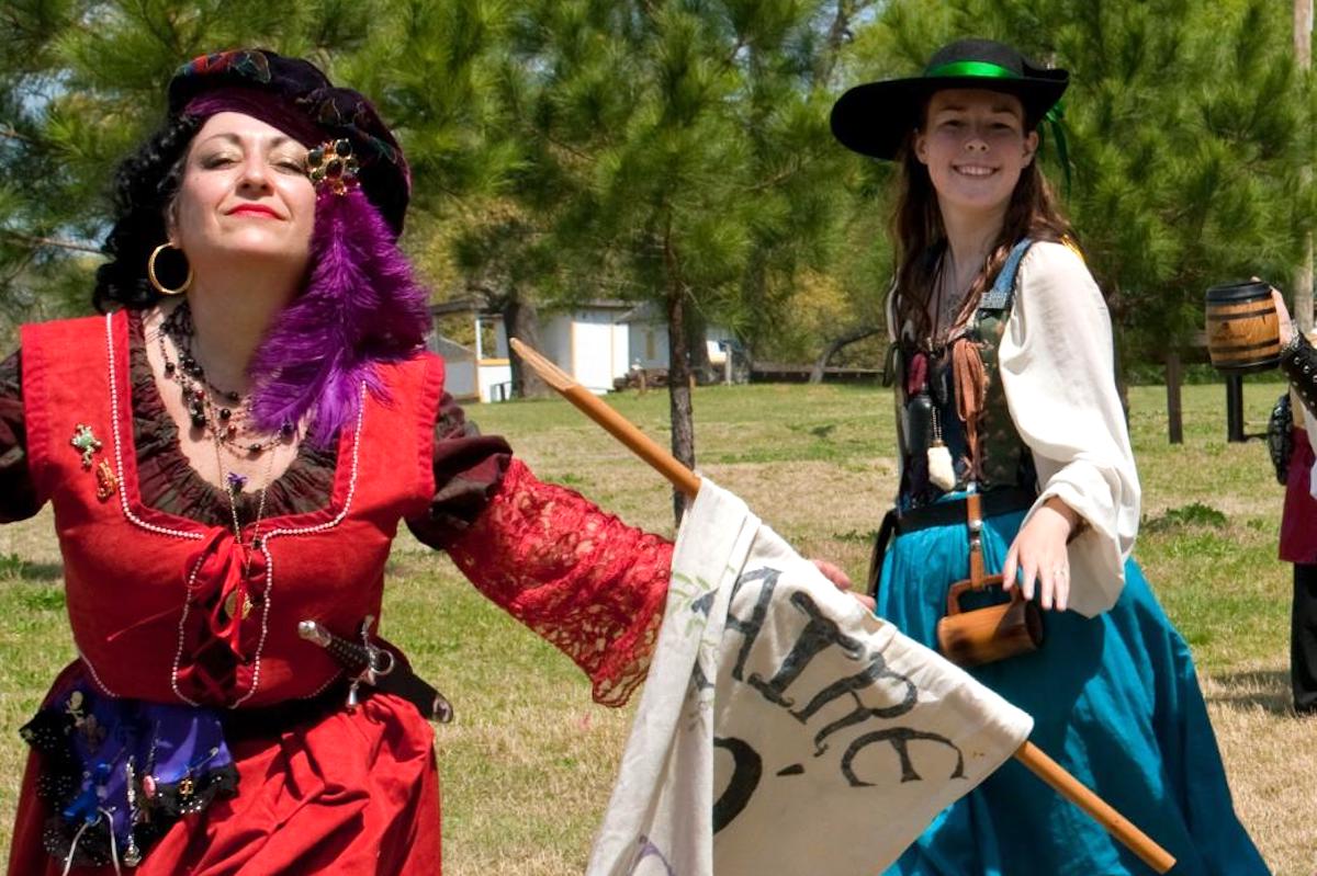 Two women in Renaissance outfits pose for the camera.