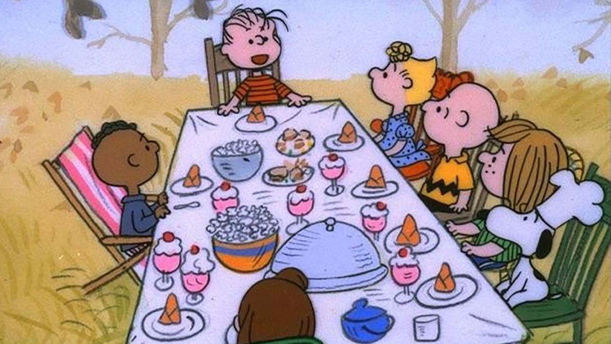 The peanuts around an outdoor thanksgiving table in A Charlie Brown Thanksgiving