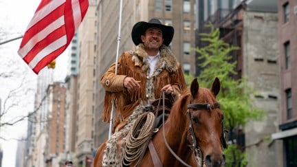 A white man (Couy Griffin) dressed like a cowboy, rides a horse in downtown Manhattan.