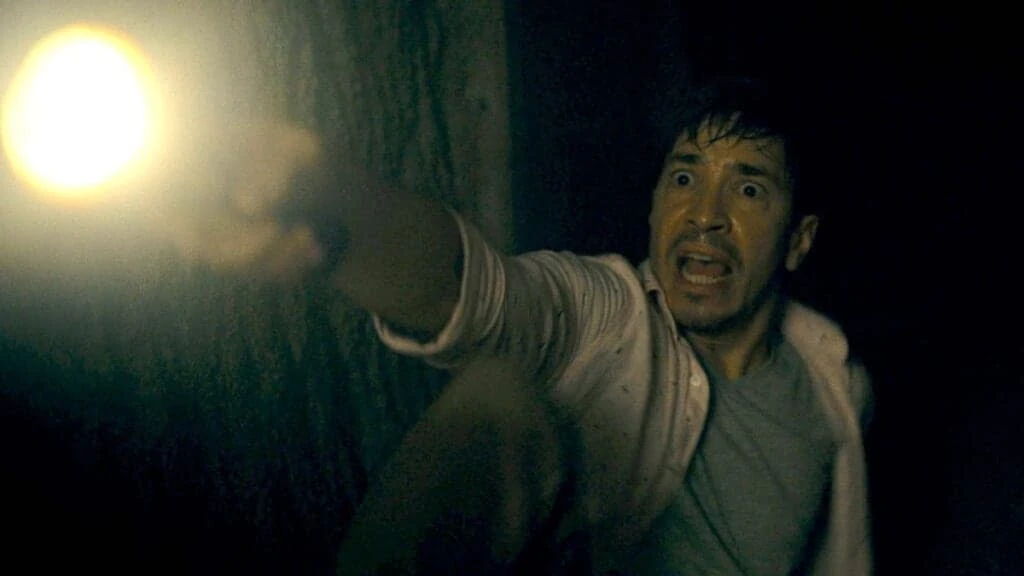A.J., in Barbarian, shines a flashlight and screams.