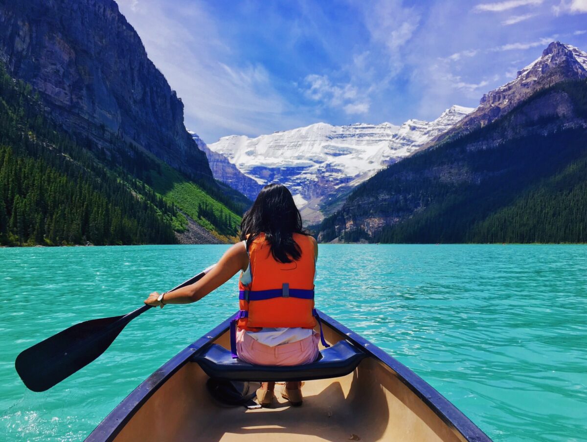 Woman canoeing in lake with mountains