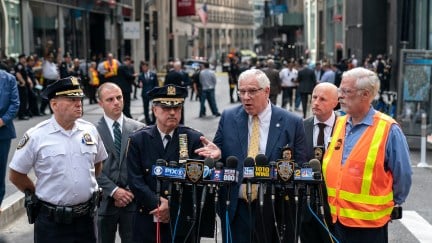 A group of older white men, some in police uniforms, speak during a press conference from a New York City street.