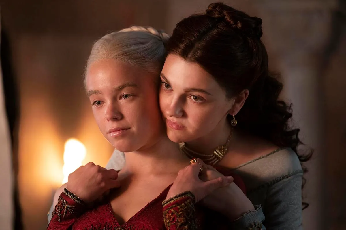 Milly Alcock as Rhaenyra is embraced by Emily Carey as Alicent on House of the Dragon