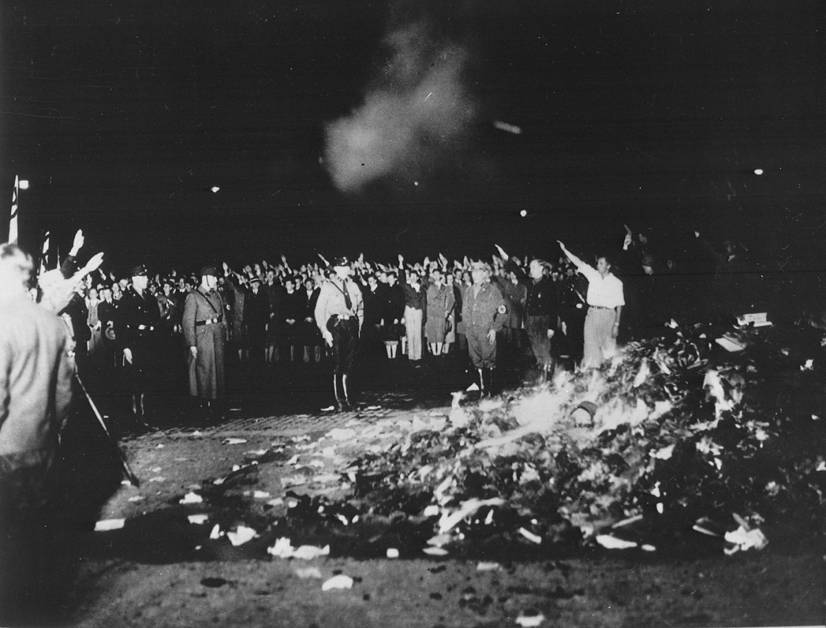 Text from archive says "The public burning of non-German writings and books on the opera square Unter den Linden in Berlin, by students of the Berlin universities! The non-German writings and books collected by the students are publicly thrown into the fire on the Opernplatz in Berlin." Image: CC BY-SA 3.0 de.