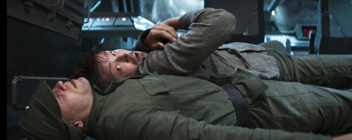 Cassian Andor lying on a Imperial officer in Andor