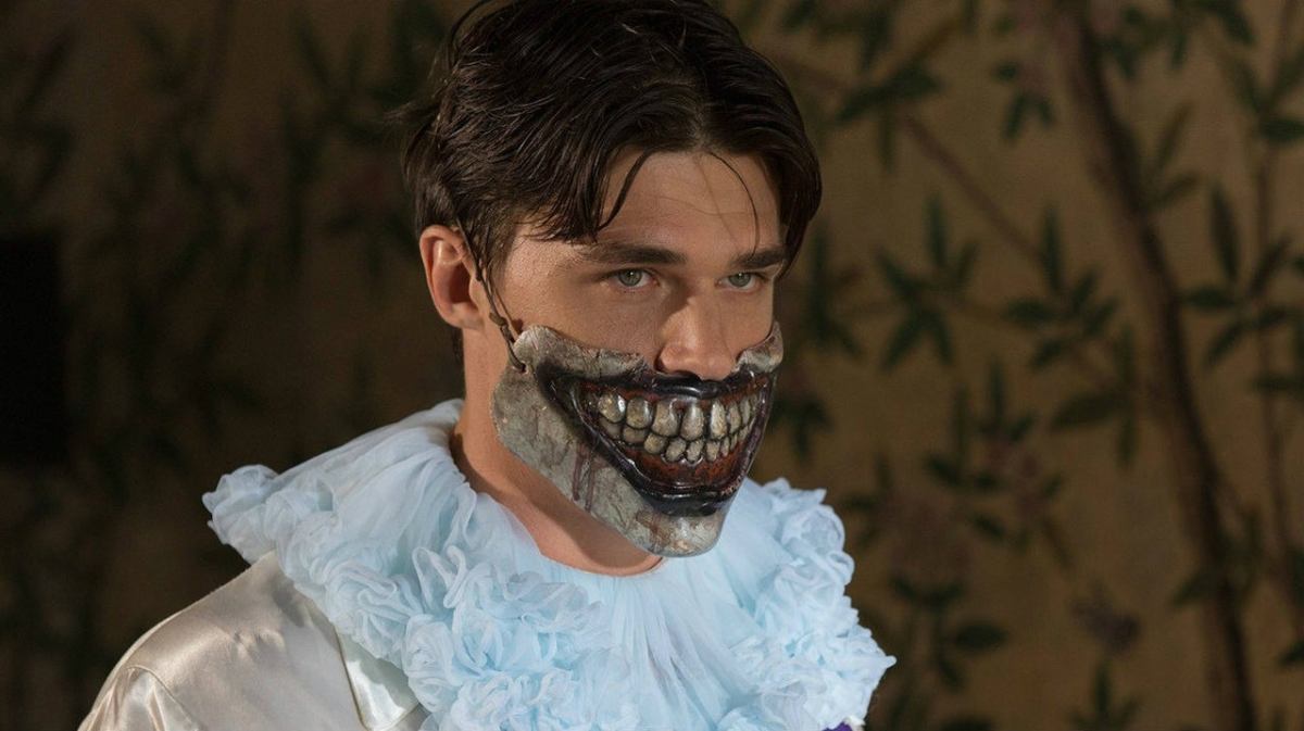 Dandy (Finn Wittrock) wears a Twisty the Clown mask over his mouth in AHS: Freak Show