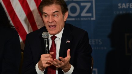 Dr. Oz looks flustered while speaking into a microphone at a campaign event.