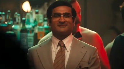 Kumail Nanjiani smiles in a nightclub as Somen Banerjee in Welcome to Chippendales.
