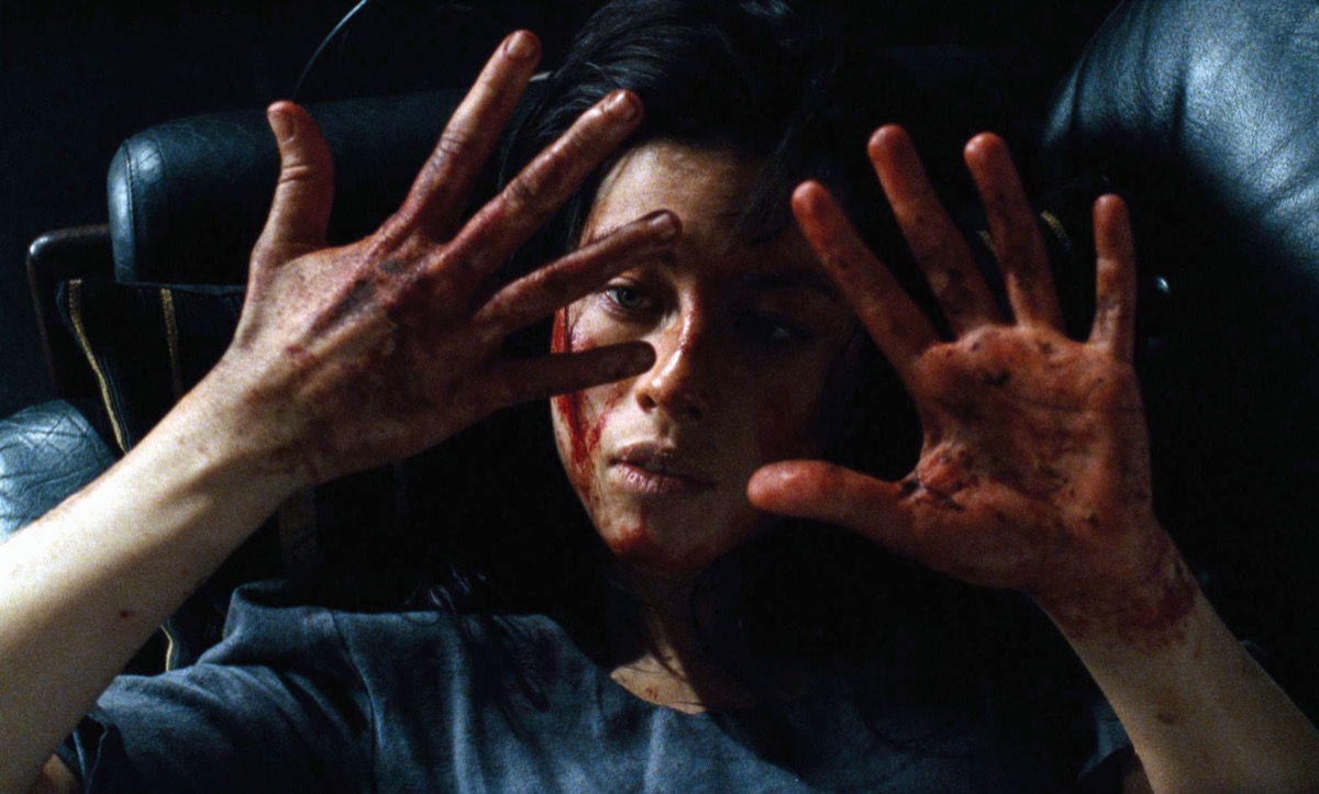 A woman lays down and gazes at her bloody hands in "Martyrs"  