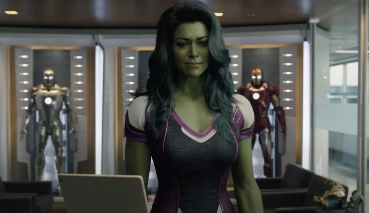 Jennifer Walters aka She-Hulk stands in Hulk form, waiting at secretary desk of a production office