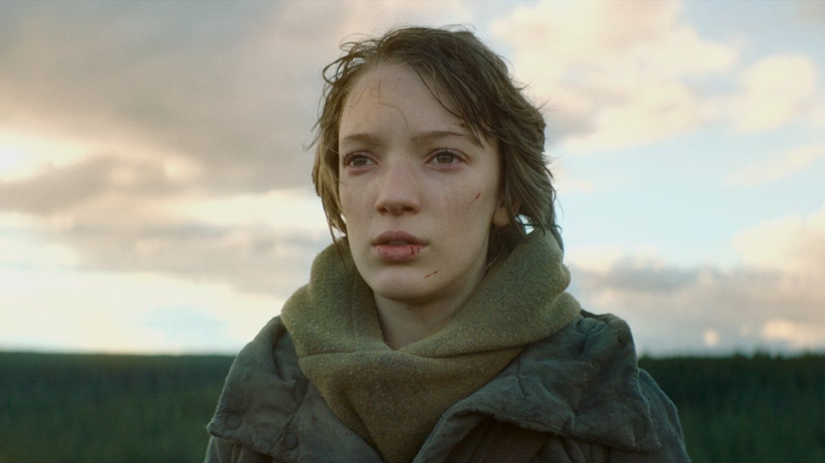 Vesper (Raffiella Chapman) looks pensively beyond the camera.