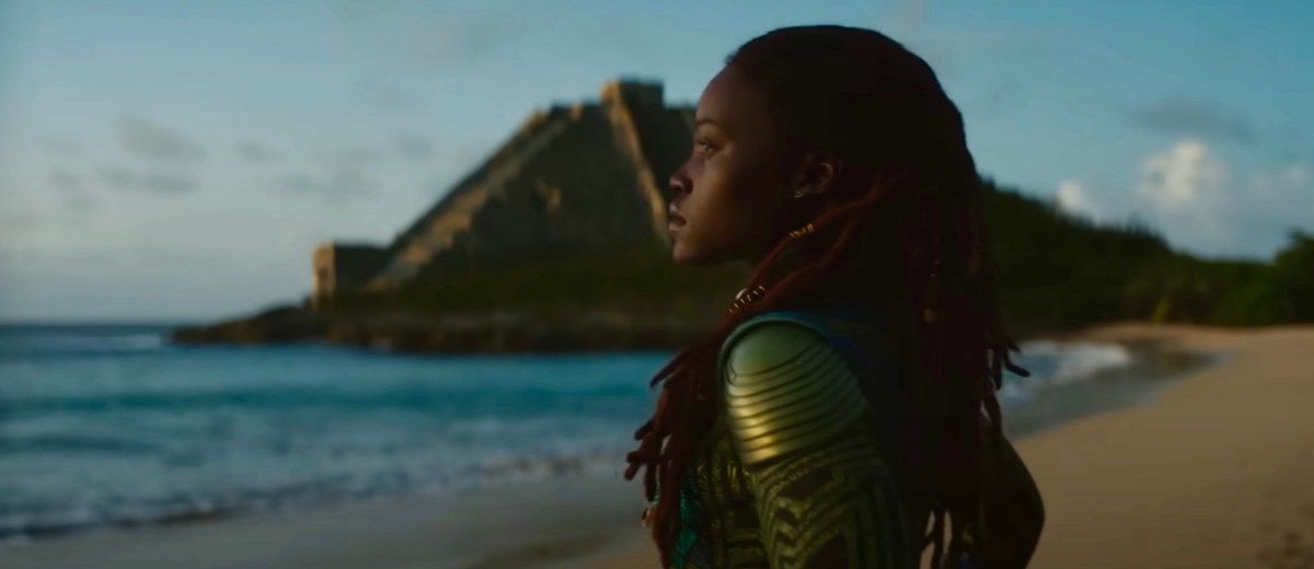 Nakia stands on a beach.