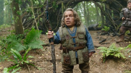 Willow (Warwick Davis) stands in the forest with a staff.